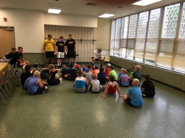 High school football players read to students in Community Recreation Program