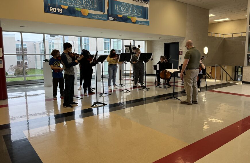 Orchestra students record spring performance around various locations at high school